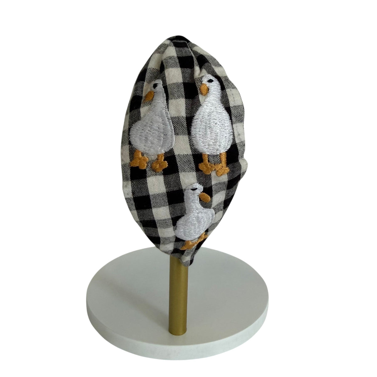 The Marigold Story handcrafted padded headband in black and white gingham fabric with embroidered duck motifs.