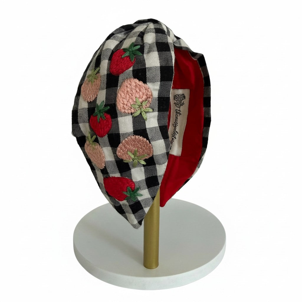 The Marigold Story handcrafted black and white gingham headband with red and pink embroidered strawberry motifs.