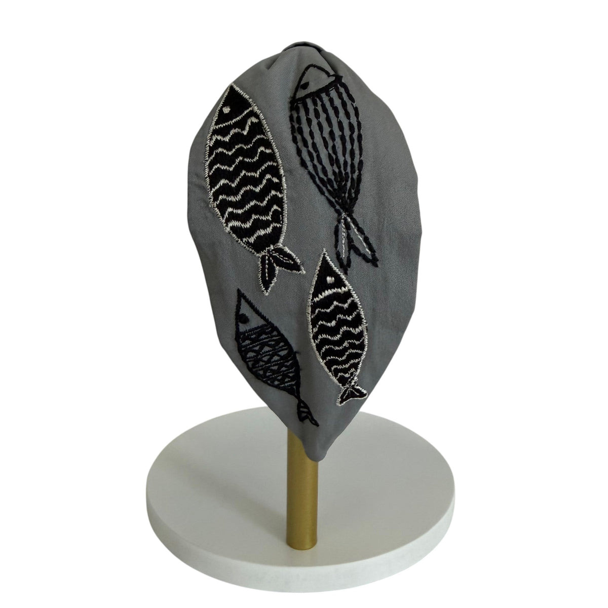 The Marigold Story grey padded headband featuring hand-embroidered black and white abstract fish motifs