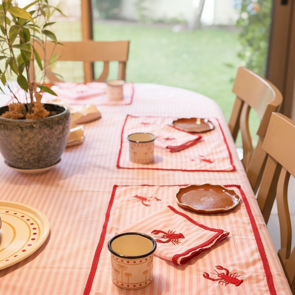 The Marigold Story handcrafted pink striped table linen set with red lobster embroidery and red lace border details.