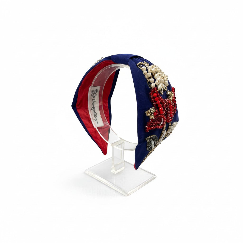 The Marigold Story navy blue headband with red beaded floral motifs, pearl clusters, and gold crystal embellishments.