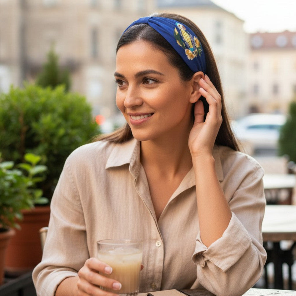 The Marigold Story navy blue padded headband with hand-embroidered tropical parrot and floral design