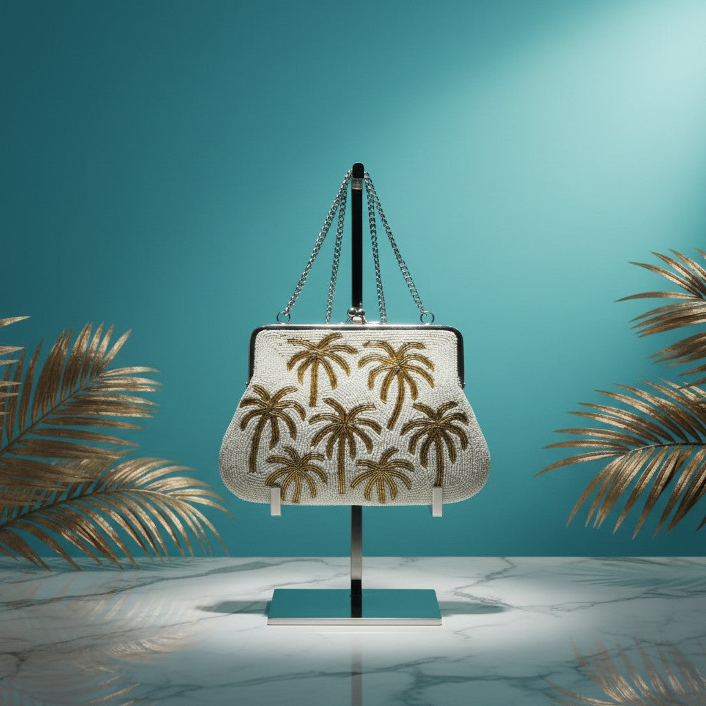 The Marigold Story white beaded sling bag with gold palm tree embroidery, metal frame, and chain strap